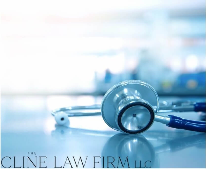 A stethoscope on a table with the Cline Law Firm logo